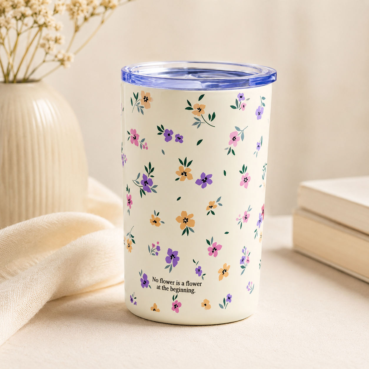 Cream floral travel tumbler with pink, purple, and yellow flowers and a clear lid on a soft neutral background.