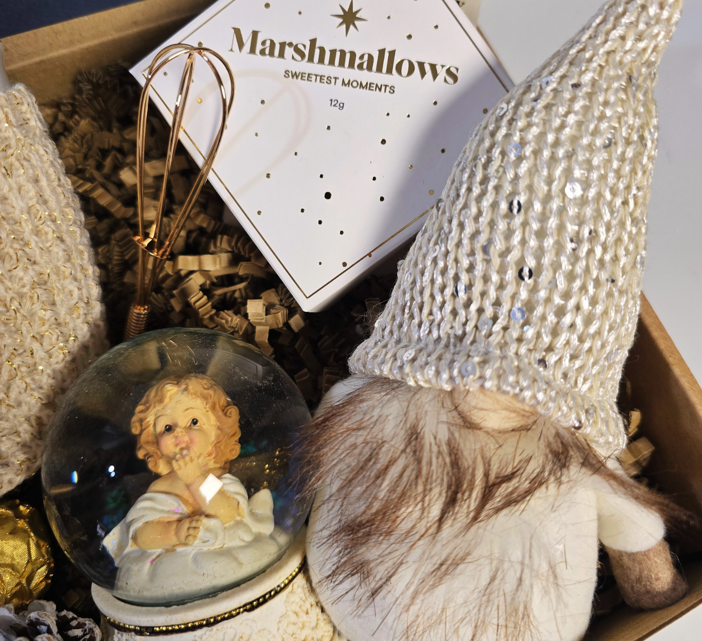 Enchanted Christmas gift box featuring a snow globe, cozy knitted mug, festive gnome, Ferrero Rocher chocolates, and gourmet marshmallows.