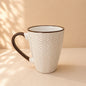 Ceramic mug with brown handle and chevron pattern on a beige background