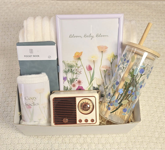 Cozy Comfort Gift Box featuring floral tumbler, mini retro speaker, soft blanket, cozy socks, photo frame, and pocket notebook — a thoughtful relaxation gift for birthdays, thank-yous, or self-care moments
