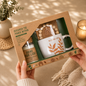 Wellness gift set in eco-friendly kraft packaging featuring a ceramic "Wild and Free" mug, scented candle, wooden bead accessory, and inspirational self-care keepsakes, beautifully displayed in a cozy lifestyle setting with soft neutral décor and warm lighting.