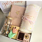 Pastel-themed gift box featuring a daisy glass tumbler, floral notebook, soft blanket with pink ribbon, tulip soap, retro mini speaker, and elegant packaging — perfect self-care or birthday gift.