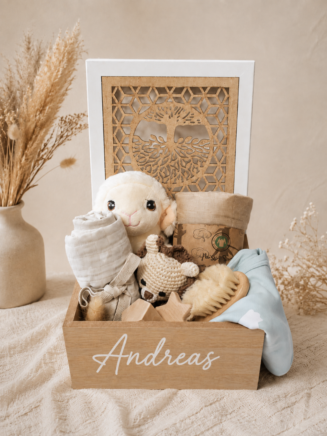 Personalized baby boy gift box with Tree of Life wooden keepsake box, plush lamb, muslin blanket, crochet toy, wooden teether, baby hair brush and soft blue baby essentials.