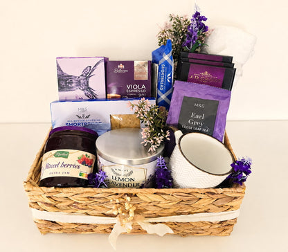Purple premium corporate gift hamper with tea, coffee, chocolate, shortbread, jam, candle and mug in a woven basket