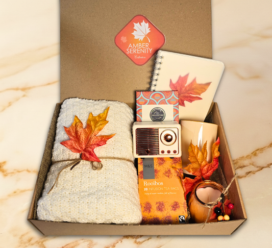 Amber Serenity Collection autumn gift box featuring a knitted blanket, M&S Rooibos tea, retro speaker, leaf notebook, and amber jar candle.