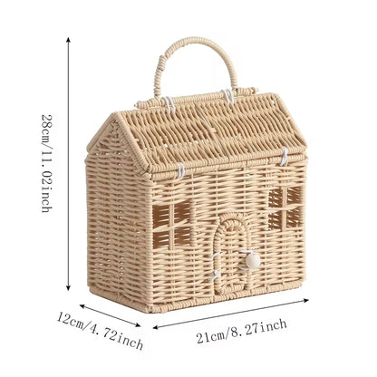 Natural woven rattan house-shaped storage basket with handle displayed on a warm neutral wooden surface.