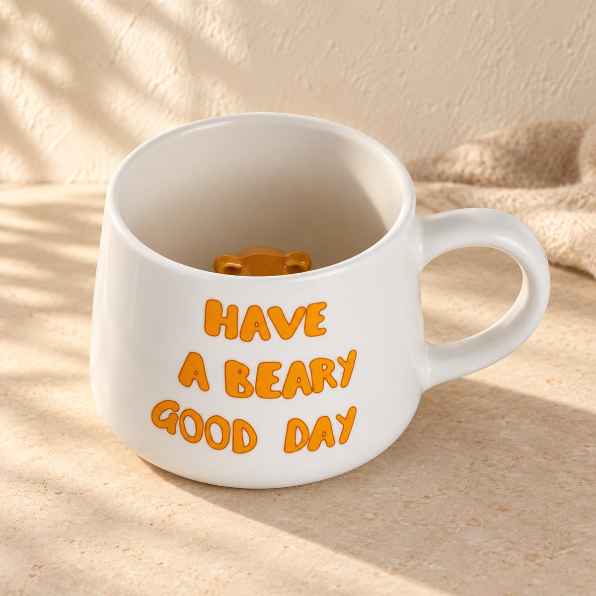 White ceramic mug with orange Have a Beary Good Day lettering and a brown 3D bear inside.