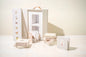 Luxury newborn baby girl gift box with educational mini library books, Mustela baby cleansing gel, FRIGG pacifier, pink knitted blanket, and soft nursery-themed packaging.