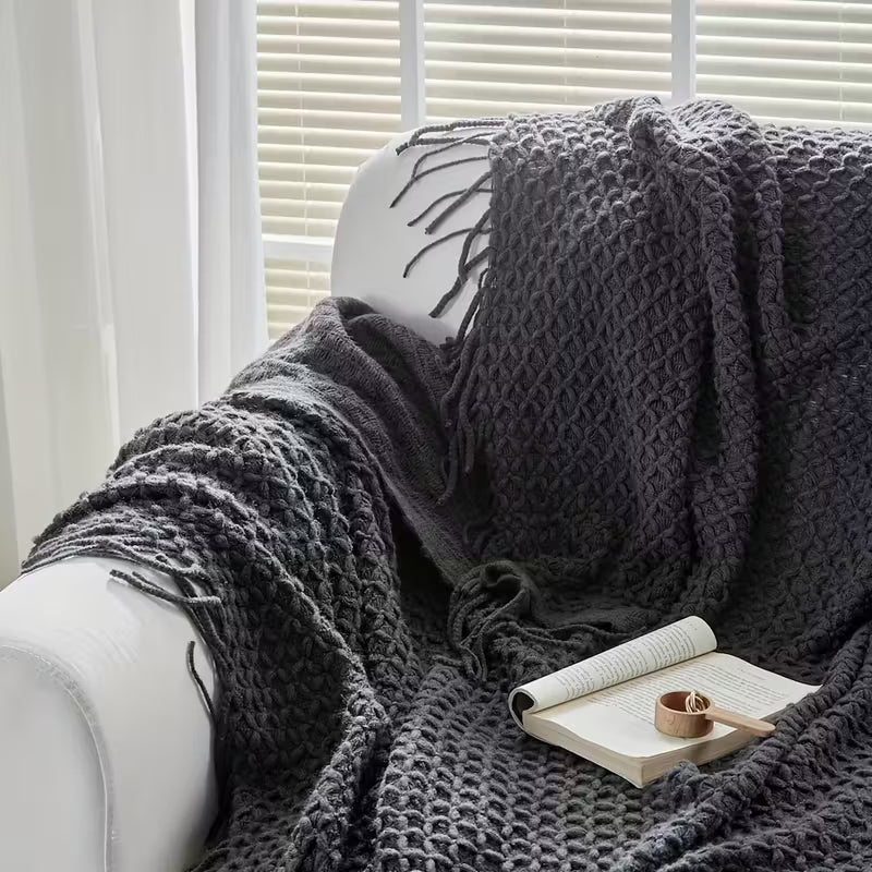 Luxury dark gray knitted throw blanket elegantly displayed in a cozy modern setting, packaged as a premium gift box for home décor and special occasions.