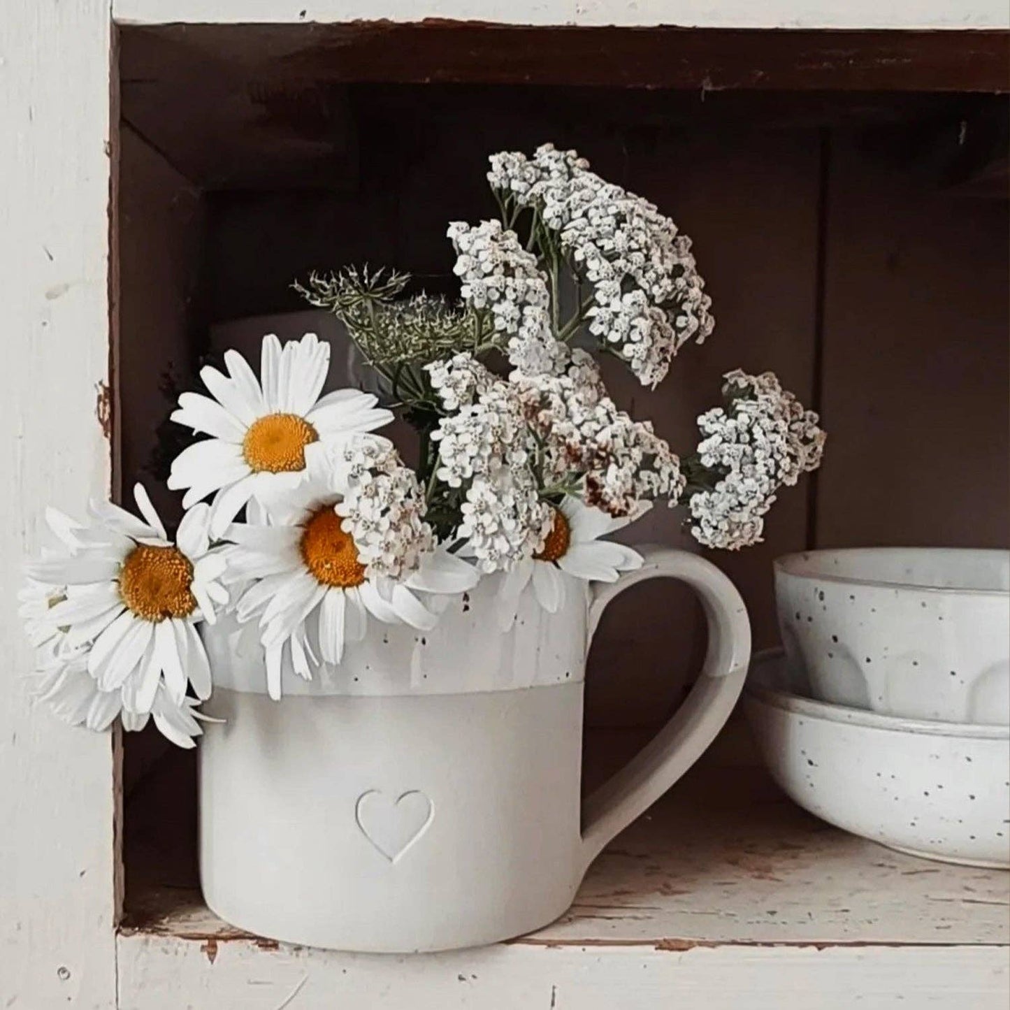 Large neutral stoneware mug with embossed heart detail, white glazed top and curved handle.