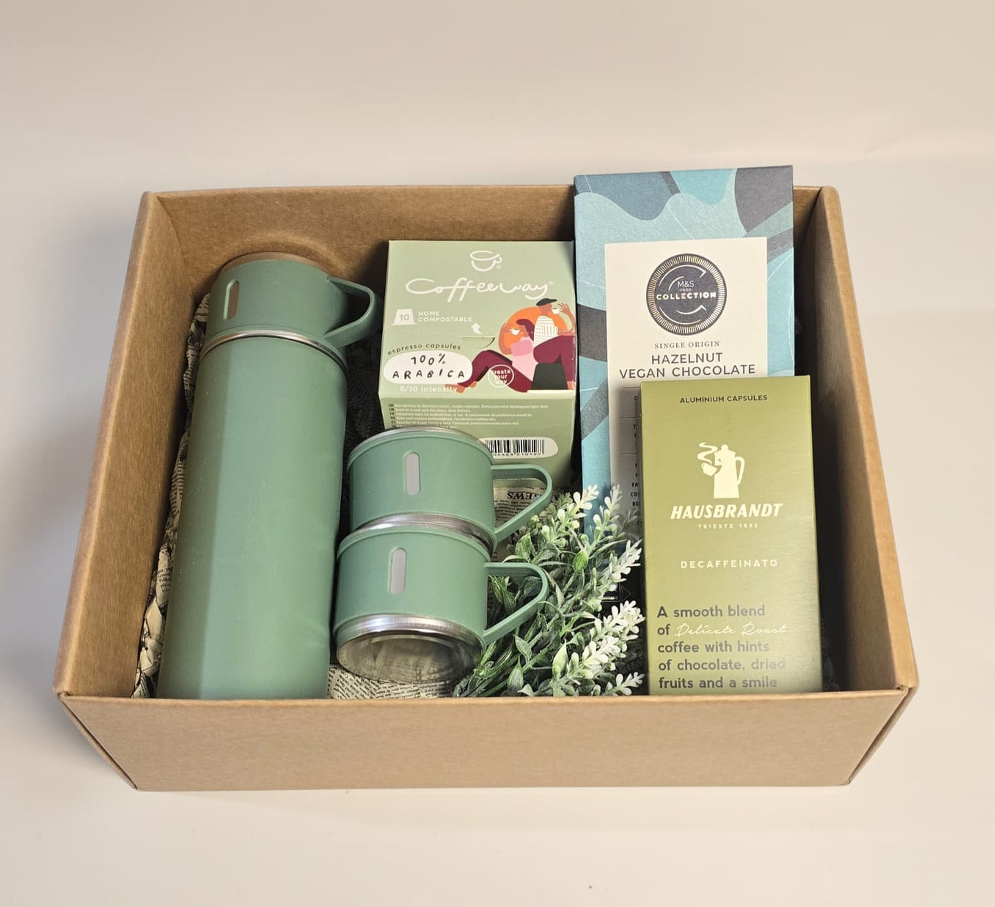 Green insulated thermos set for two with Coffeeway Arabica capsules, Hausbrandt Decaffeinato, and The Real Collection Vegan Hazelnut Chocolate.