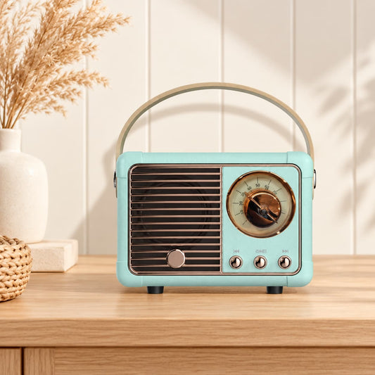 Retro portable speaker with gold-tone dial and carry handle, available in cream, sage green, blush pink and lilac.