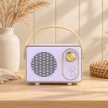 Retro portable speaker with gold-tone dial and carry handle, available in cream, sage green, blush pink and lilac.