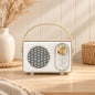 Retro portable speaker with gold-tone dial and carry handle, available in cream, sage green, blush pink and lilac.