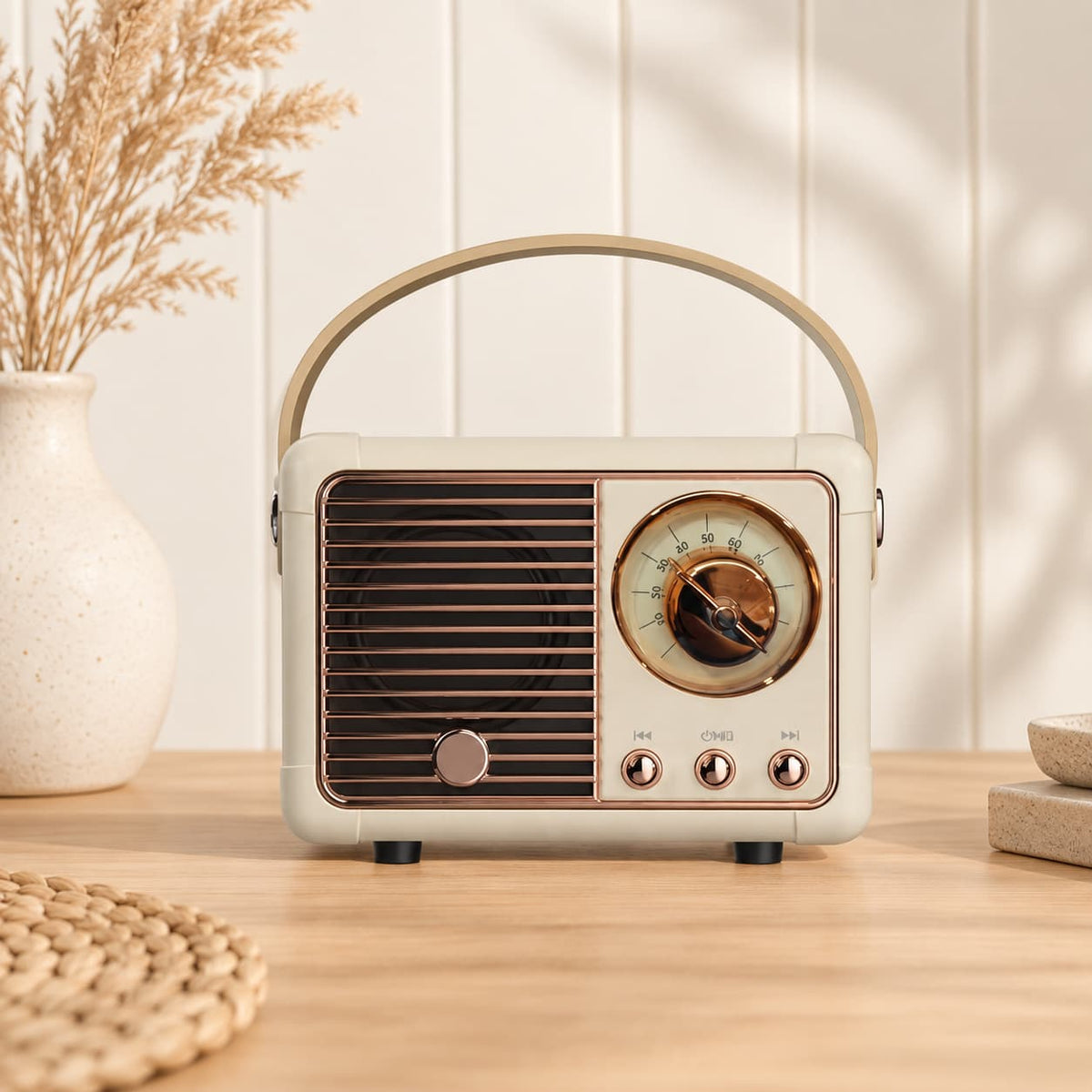 Retro portable speaker with gold-tone dial and carry handle, available in cream, sage green, blush pink and lilac.