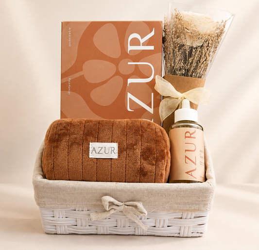 AZUR self-care gift basket with hair oil, spa box, makeup pouch and artificial flower arrangement in an elegant reusable basket.