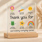 Teacher thank-you acrylic plaque with colourful flower, pencil, sun, book, star and rainbow illustrations on a wooden stand.