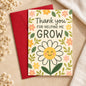 Floral thank-you card reading Thank you for helping me grow, with a smiling daisy and red envelope.