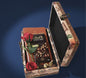 Vintage suitcase travel gift box containing a Lindt Swiss Classic chocolate bar, travel planner/sim book, and red artificial rose.